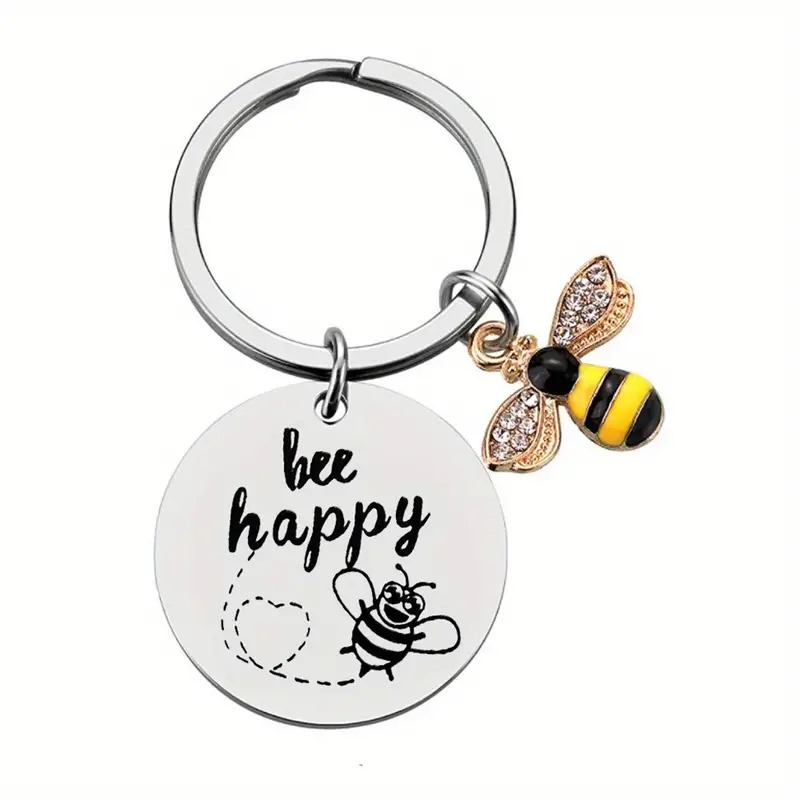 Chaveiro em aço inox com frase “Bee Happy” e pingente decorativo de abelha
